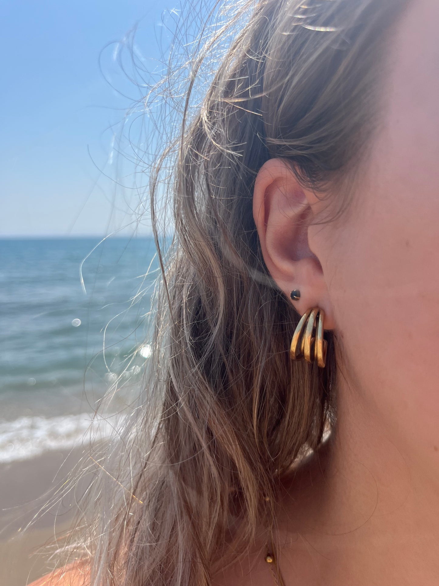 Boucles d'oreilles pour femme type créoles en acier inoxydable composées de plusieurs anneaux entrecroisés à l'effet brossé mat.