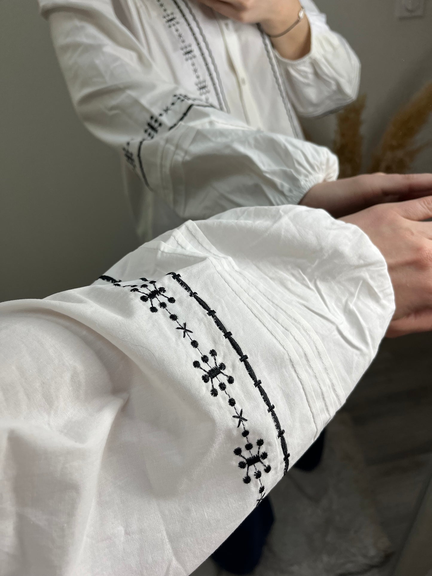 Détails brodé noir sur blouse Romy blanche avec boutons sur le devant
