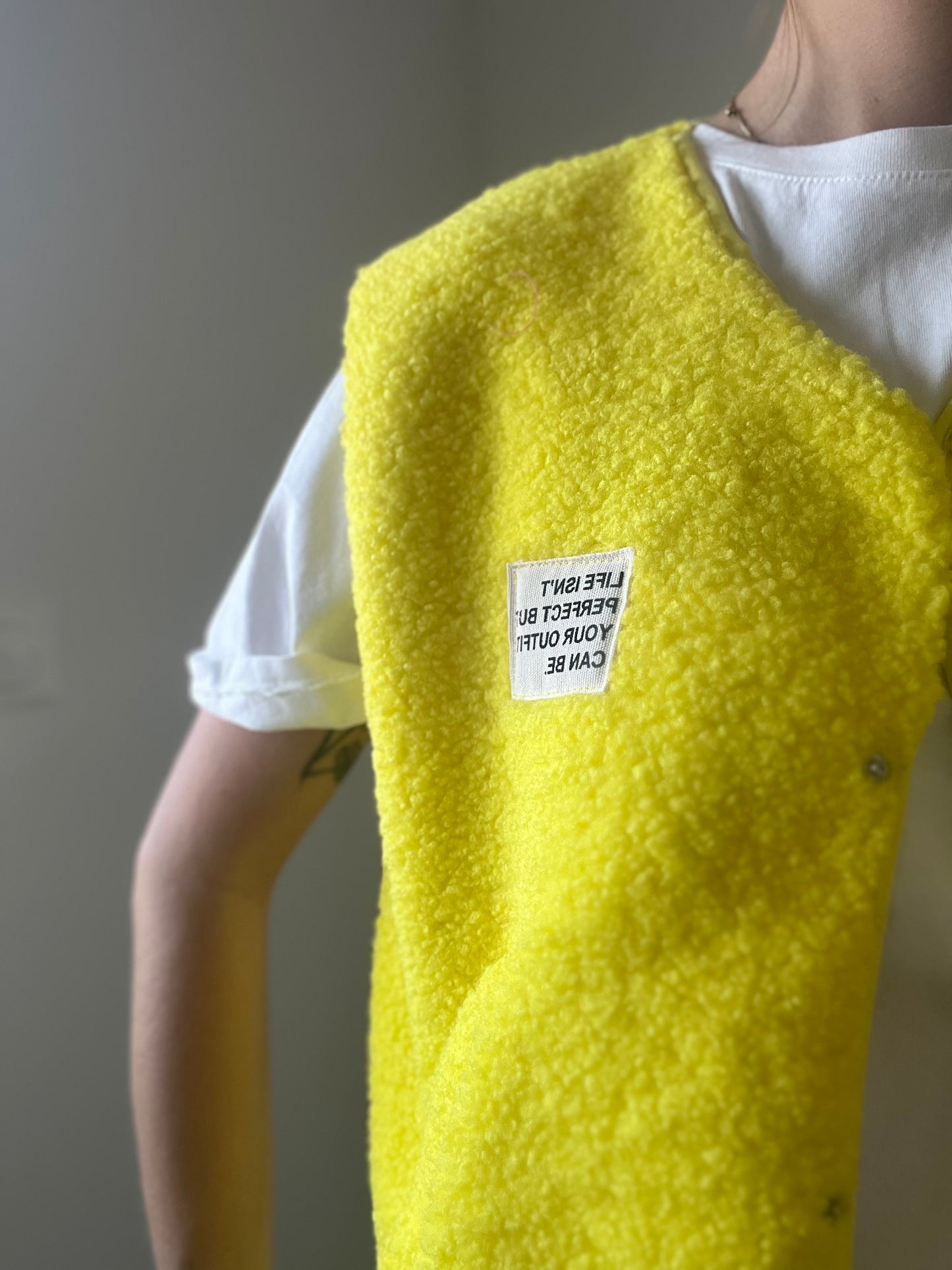 Gilet de couleur jaune avec boutons sur le devant deux poches su le cote