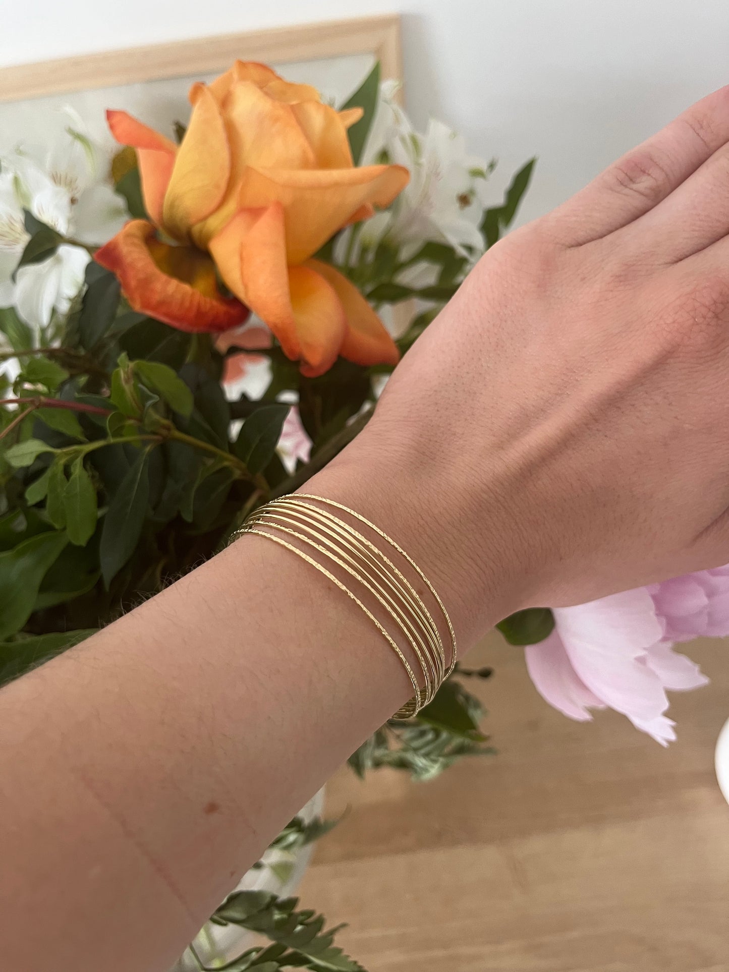 Bracelet type jonc semainier en acier inoxydable composé de 7 anneaux (4 striés et 3 lisses).