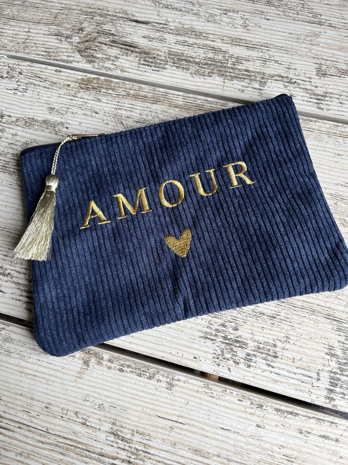 Pochette multi-usages, pratique pour y ranger tout type d'affaires (toilettes, maquillage etc.) avec son pompon décoratif. avec "AMOUR" et un coeur brodé, et son pompon décoratif.