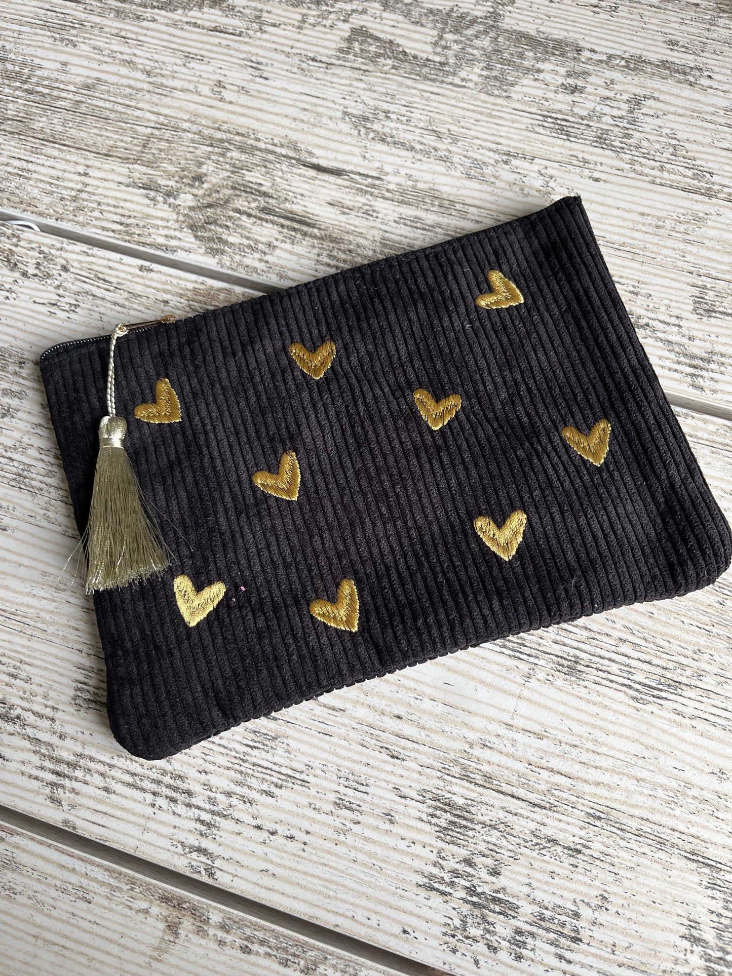 Pochette multi-usages, pratique pour y ranger tout type d'affaires (toilettes, maquillage etc.) avec son pompon décoratif. Des coeurs sont brodés sur le dessus de la trousse en velours côtelé et de jolis motifs floraux ou de petits carreaux sont imprimés à l'intérieur de la pochette.