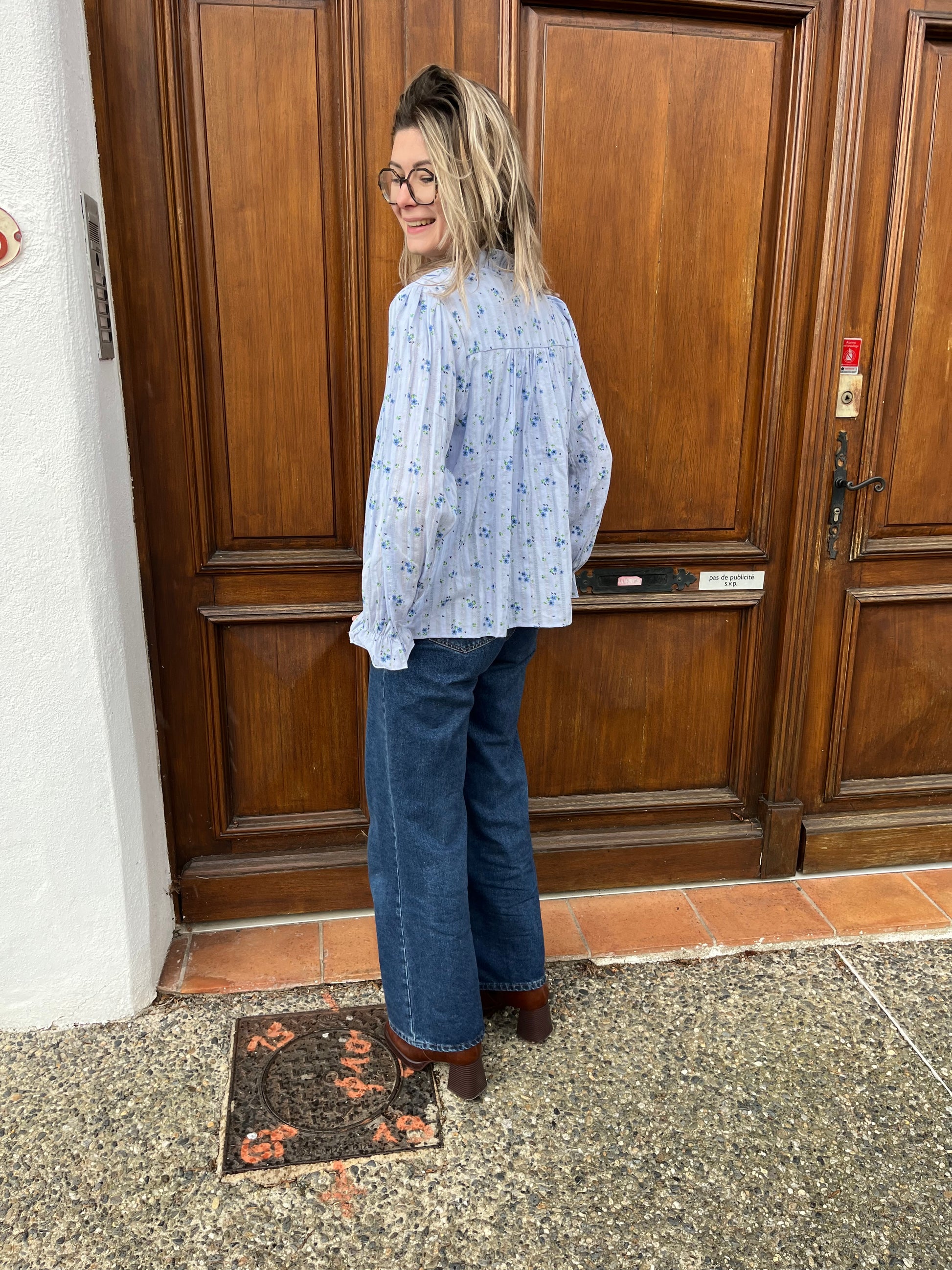 Blouson avec bouton sur le devant en col V de couleur bleue, avec des motifs à fleurs de couleur bleue foncée