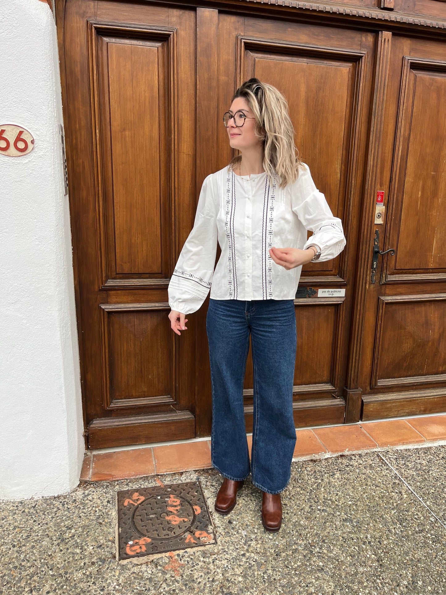 Blouse pour femmes avec bouton sur le devant de couleur blanche et motif noir sur la blouse