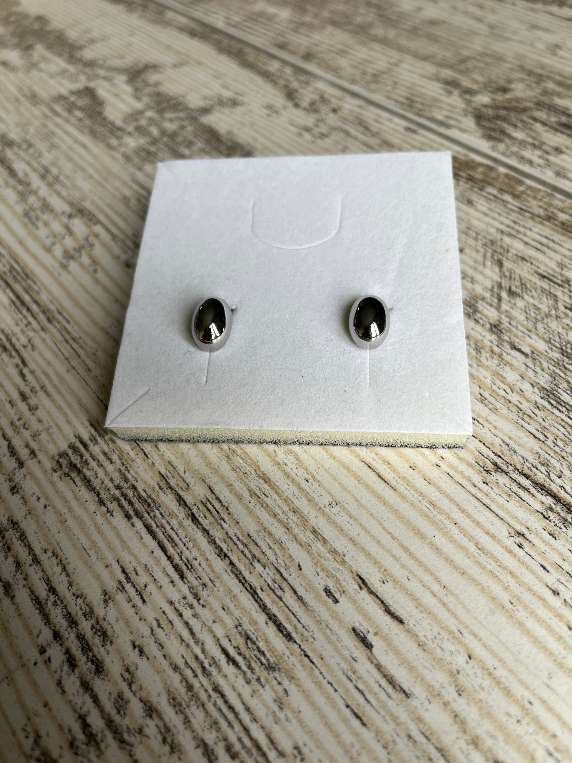 Boucles d'oreilles à puce en acier inoxydable composées d'une pièce ovale creuse.