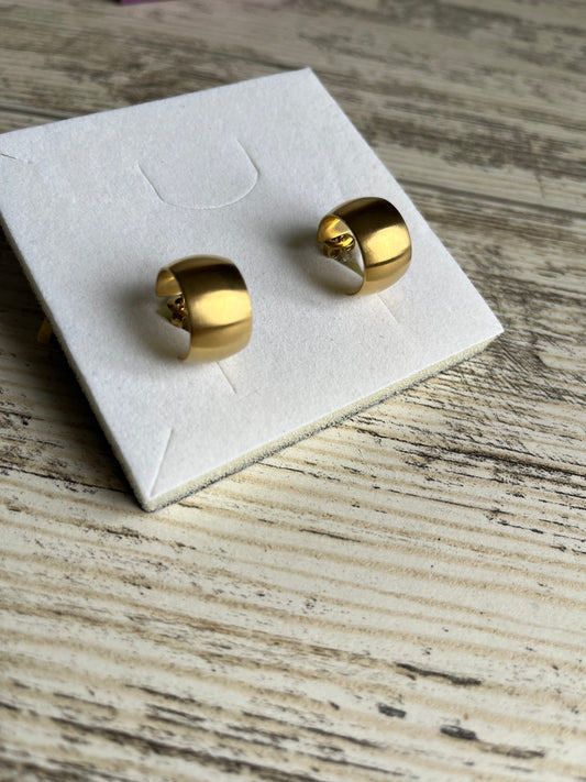 Boucles d'oreilles type créoles en acier inoxydable composées d'un anneau large et plat avec un effet brossé.