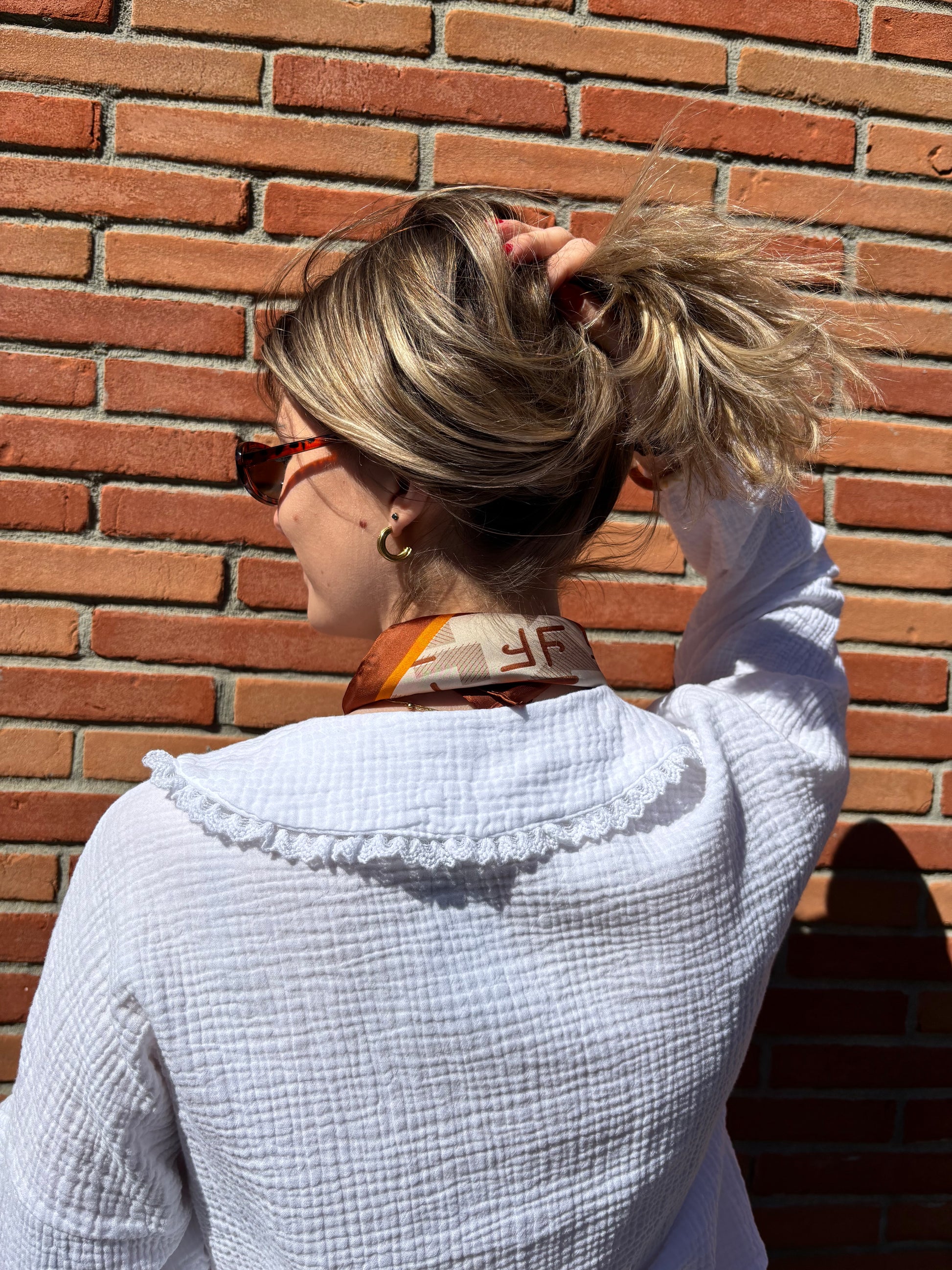 Foulard soyeux marron à motifs pour femme, idéal pour un look élégant et moderne au quotidien.