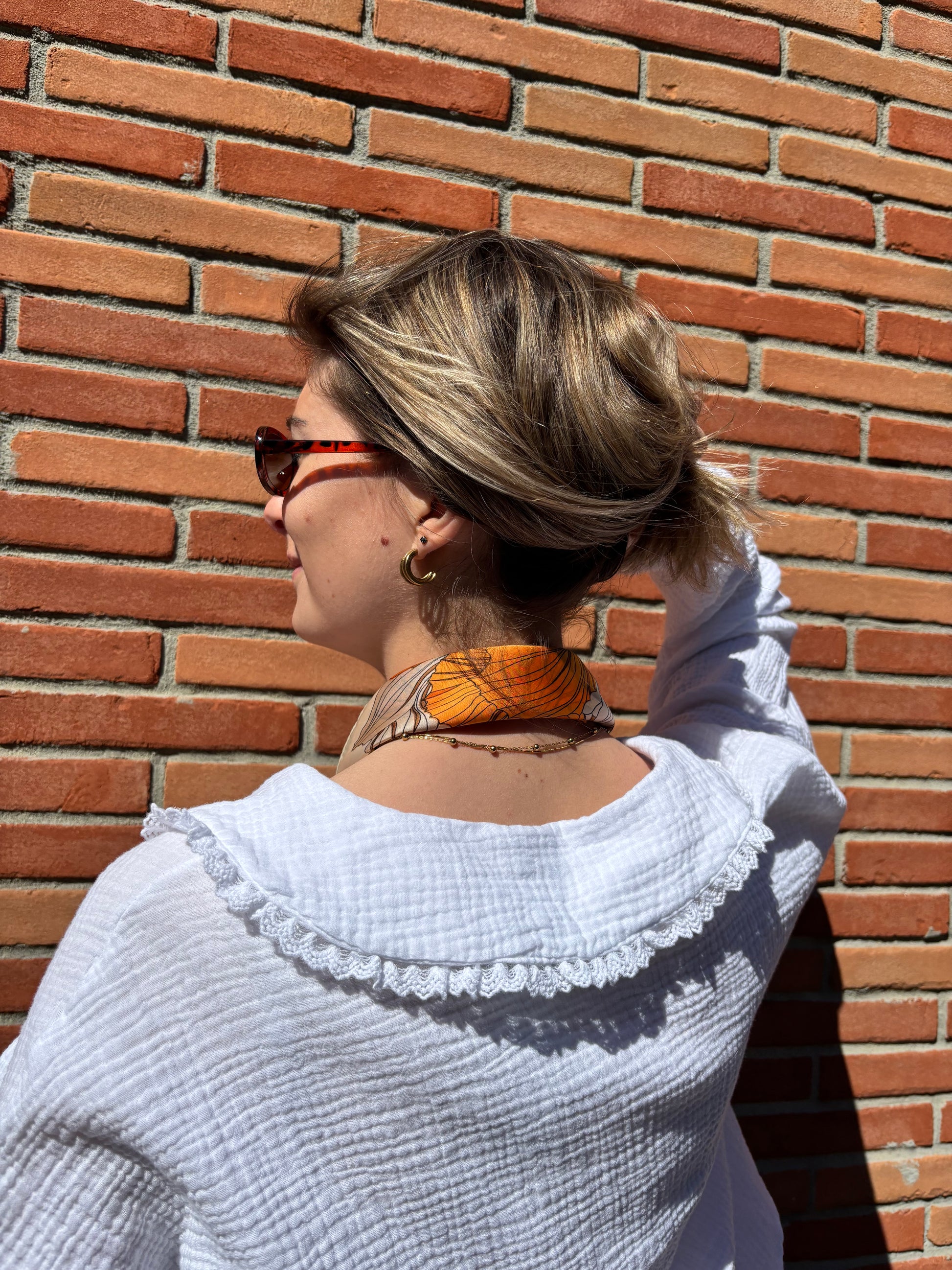 Foulard en soie aux imprimés floraux orange et blanc, idéal pour apporter une note lumineuse et raffinée à votre style.