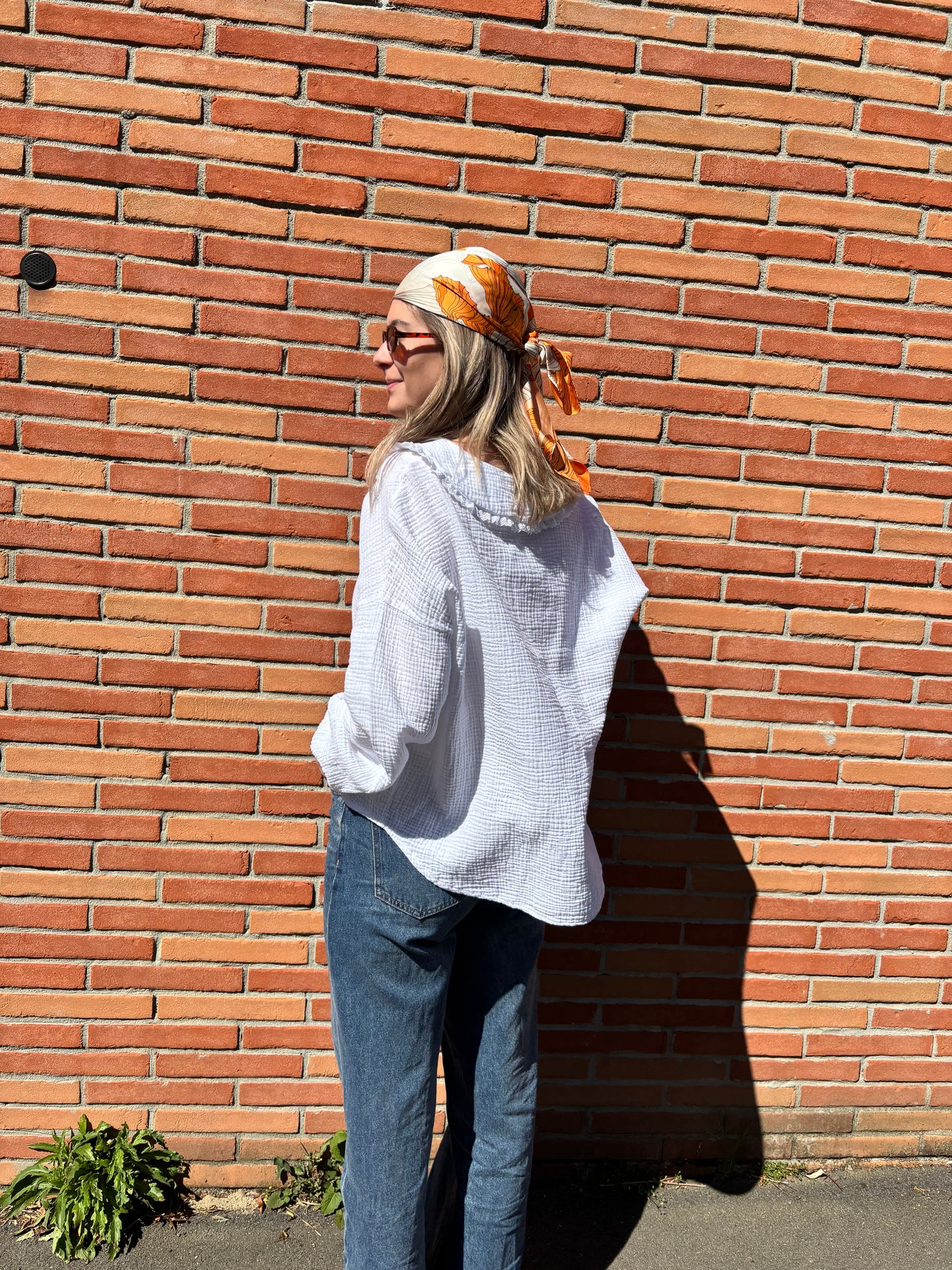 Élégant foulard en soie pour femme avec motifs fleurs orange et blanc, une pièce tendance qui rehausse instantanément votre look.
