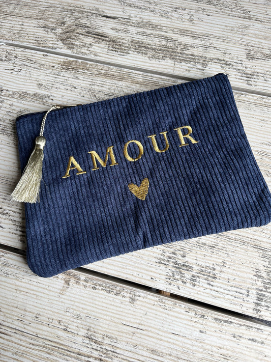 Pochette multi-usages, pratique pour y ranger tout type d'affaires (toilettes, maquillage etc.) avec son pompon décoratif. avec "AMOUR" et un coeur brodé, et son pompon décoratif.