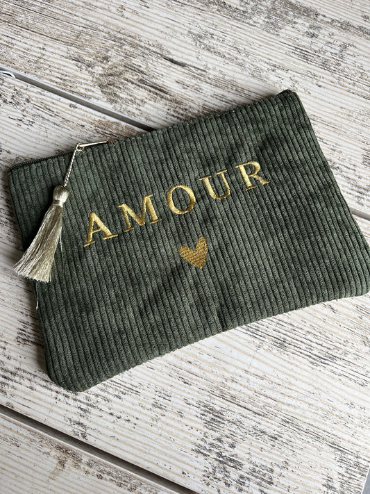 Pochette multi-usages, pratique pour y ranger tout type d'affaires (toilettes, maquillage etc.) avec son pompon décoratif. avec "AMOUR" et un coeur brodé, et son pompon décoratif.