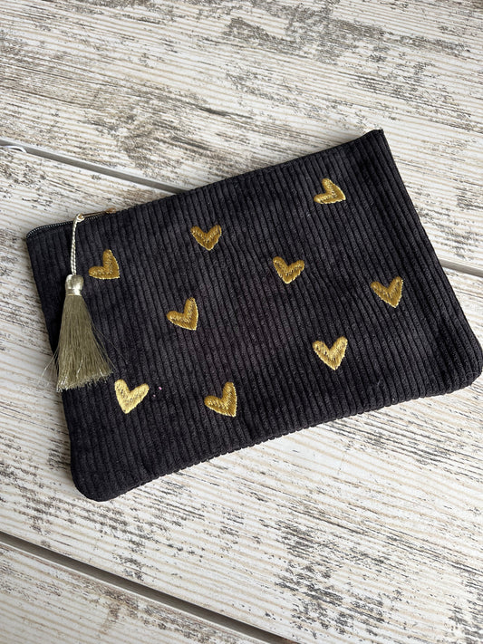 Pochette multi-usages, pratique pour y ranger tout type d'affaires (toilettes, maquillage etc.) avec son pompon décoratif. Des coeurs sont brodés sur le dessus de la trousse en velours côtelé et de jolis motifs floraux ou de petits carreaux sont imprimés à l'intérieur de la pochette.