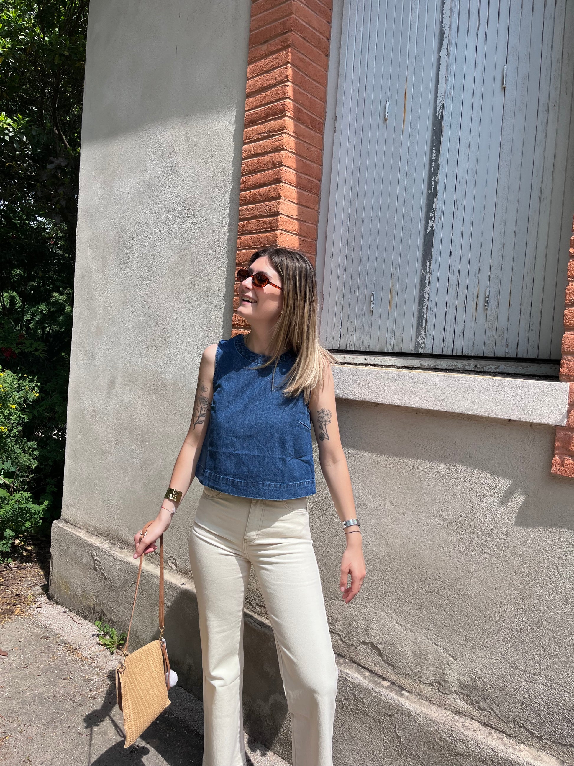Un débardeur en jean élégant avec détails nœuds au dos, parfait pour un look féminin et raffiné.