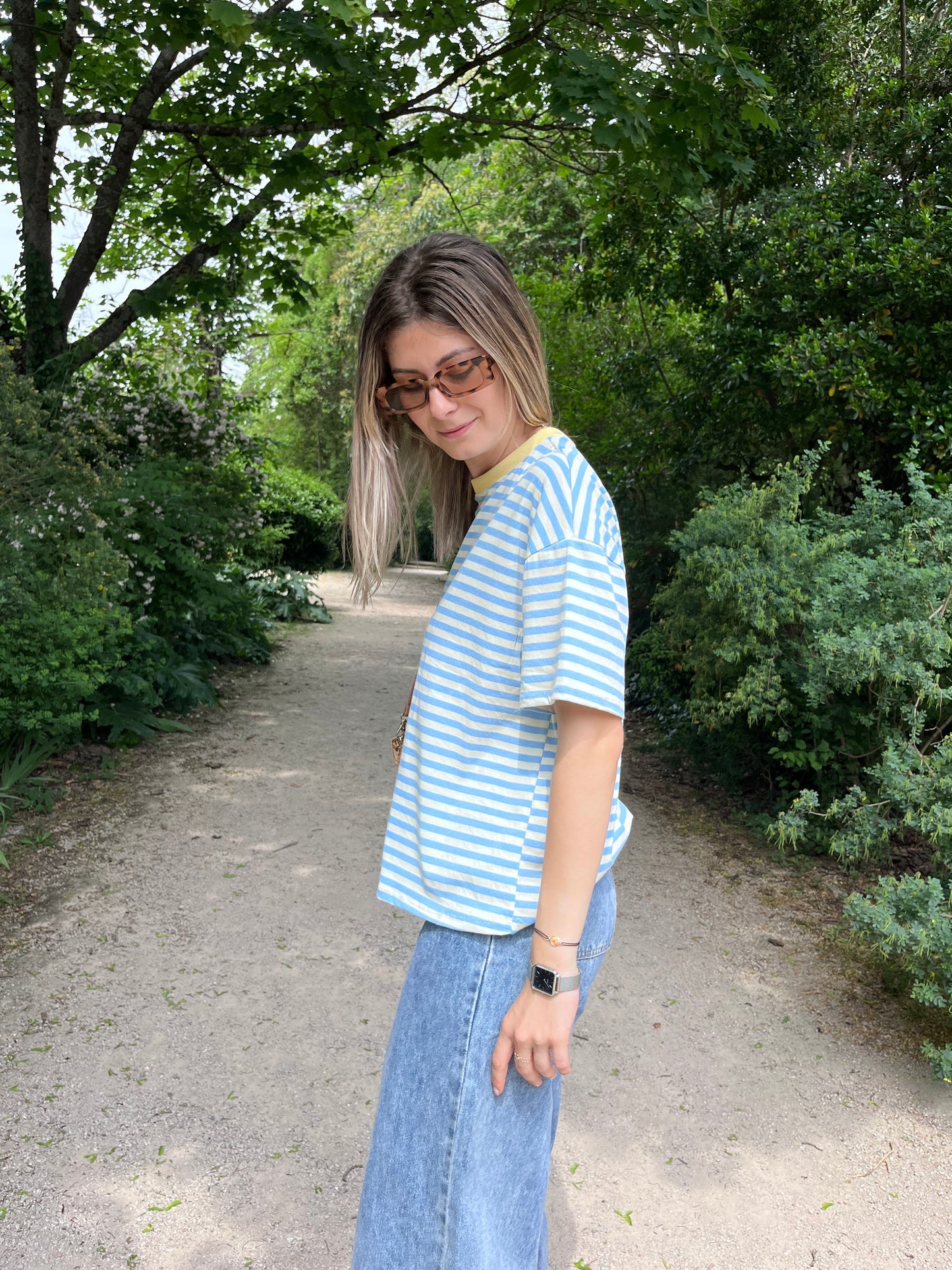 Allie confort et style avec ce t-shirt rayé bleu et blanc. Son col jaune apporte une note ensoleillée et originale.